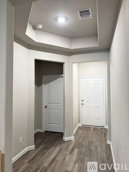 A hallway with two doors and a skylight.