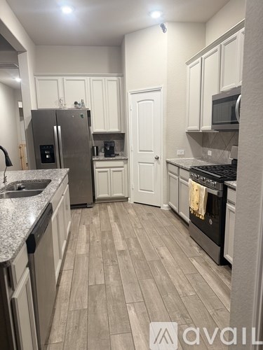 A kitchen with a refrigerator, sink, and oven.