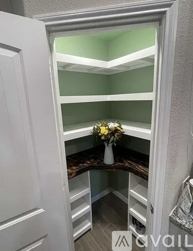 A white cabinet with a vase of flowers on top.