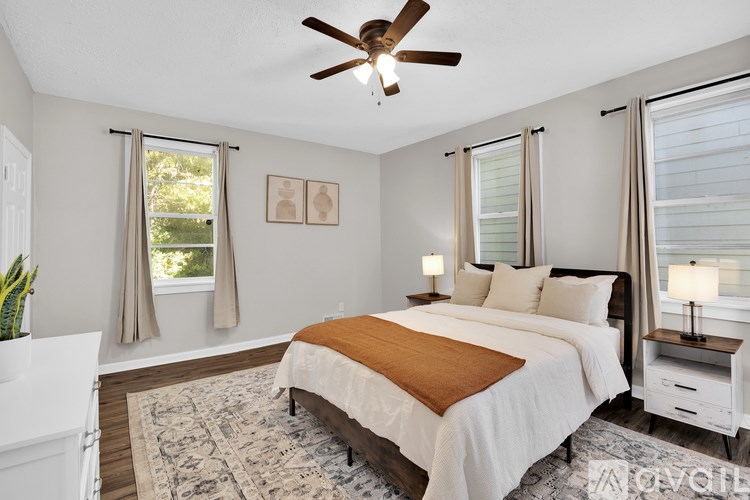 A bedroom with a large bed and a ceiling fan.