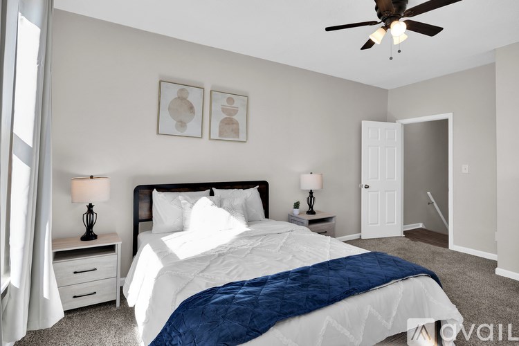 A bedroom with a large bed and a ceiling fan.
