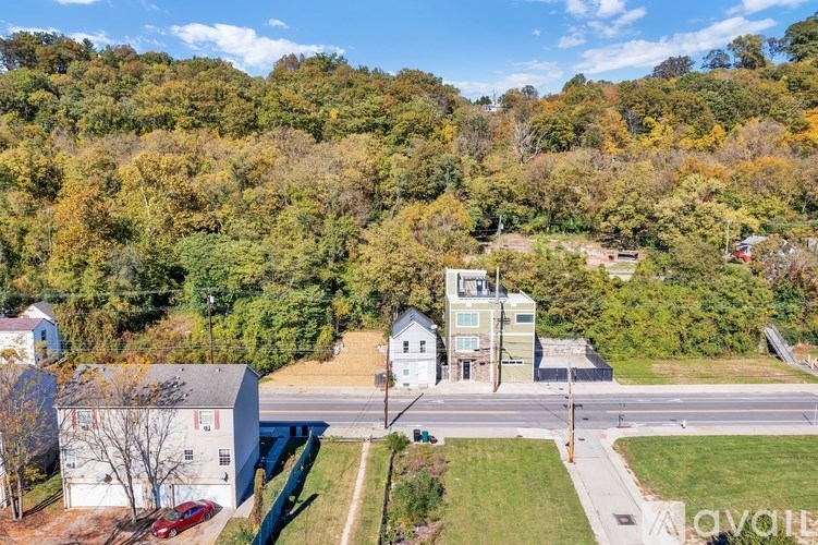 A bird's eye view of a street with a white building on the right and a red car parked on the left.