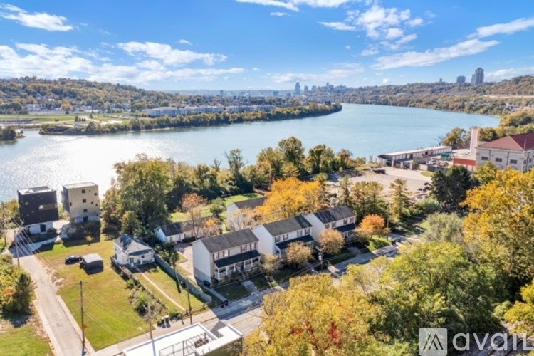 A bird's eye view of a residential area with houses and a river in the background.