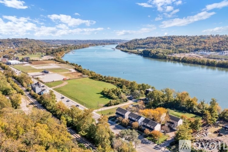 A river flows through a town with a mix of residential and green areas.