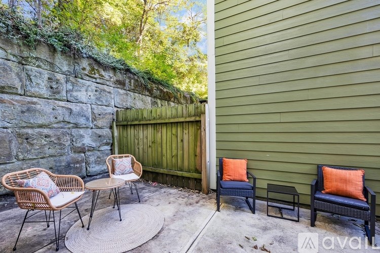 A patio with a stone wall and a wooden fence.