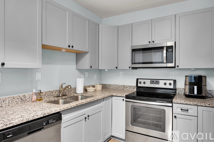 A kitchen with white cabinets and a granite countertop.