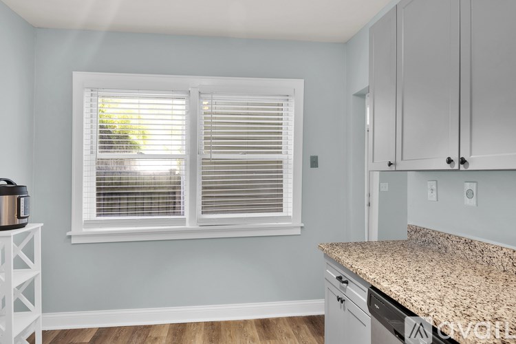 A kitchen with a granite countertop and white cabinets.