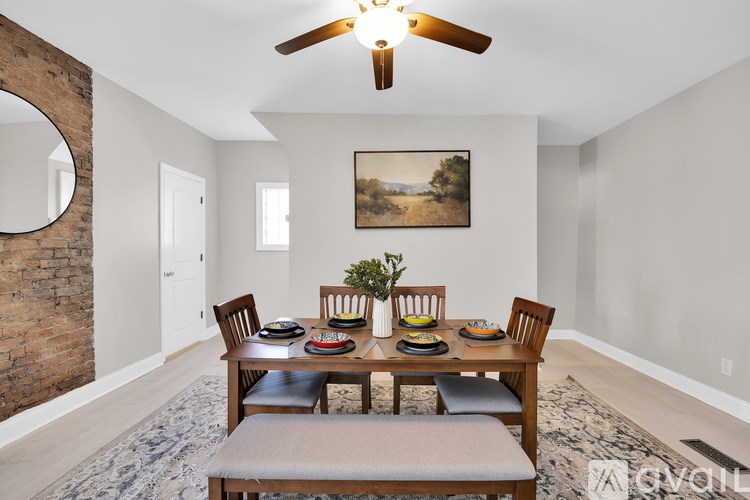 A dining room with a wooden table and chairs.