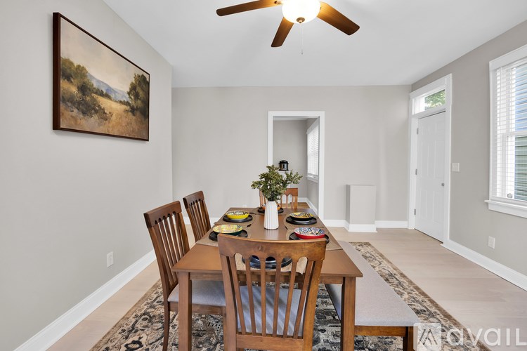 A dining room with a table set for four.