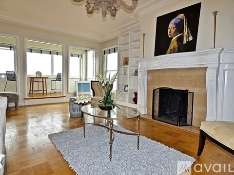 A living room with a fireplace and a painting on the wall.