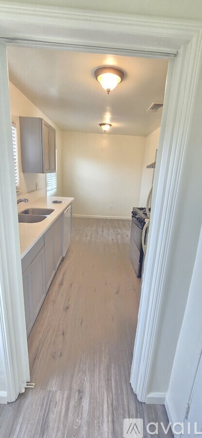 A kitchen with a white cabinet and a light brown floor.