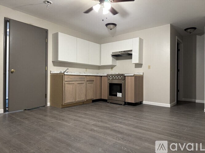 A modern kitchen with a wood stove and a ceiling fan.
