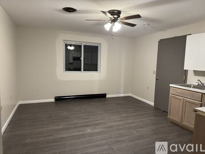 A room with a ceiling fan and a window.