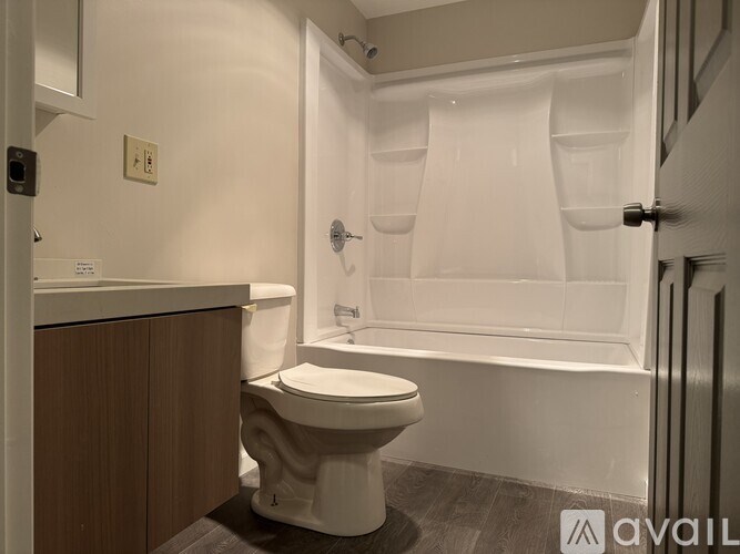 A white toilet sits next to a bathtub in a bathroom.