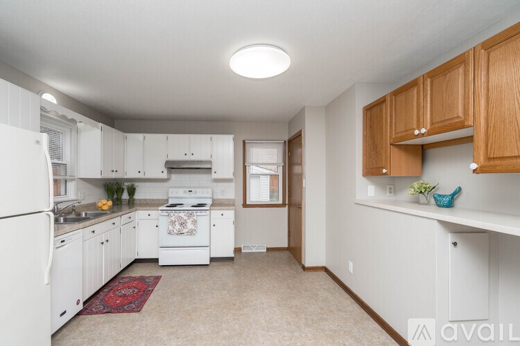 A kitchen with white appliances and wooden cabinets.