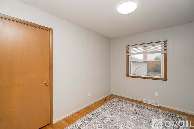 A room with a wooden door and a window with blinds.