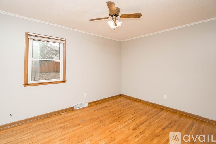 A room with a wooden floor and a ceiling fan.