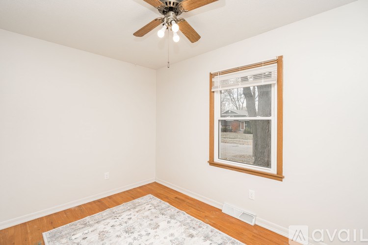 A room with a ceiling fan and a framed picture on the wall.
