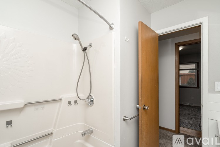A bathroom with a white tub and a wooden door.