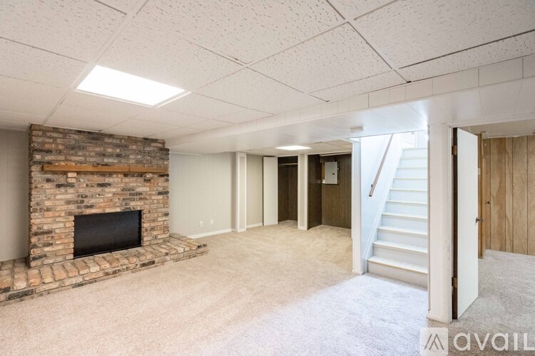 A living room with a fireplace and a staircase.