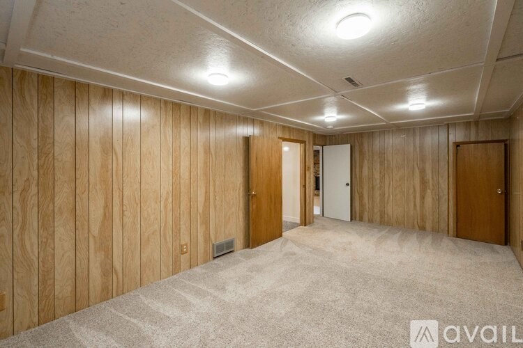 A room with wooden walls and carpeted floor.