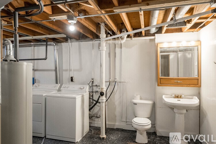 A bathroom with a toilet, sink, and a washing machine.