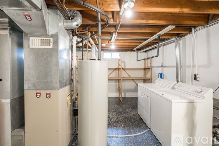 A room with a white furnace and a smaller unit to the left.