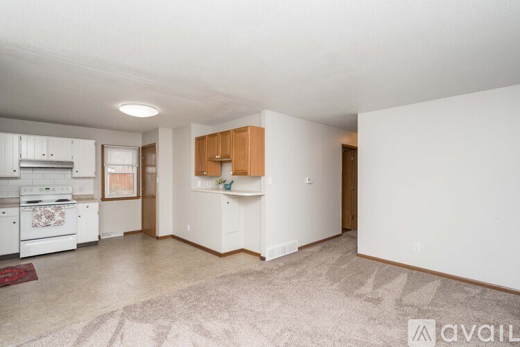 A kitchen with white appliances and wooden cabinets.