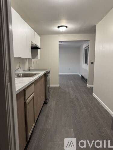 A kitchen with a refrigerator, sink, and cabinets.