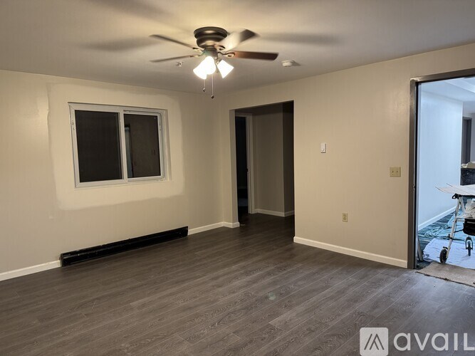 A room with a ceiling fan and a window.