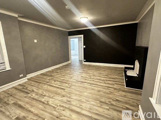 A room with wooden flooring and a white door.