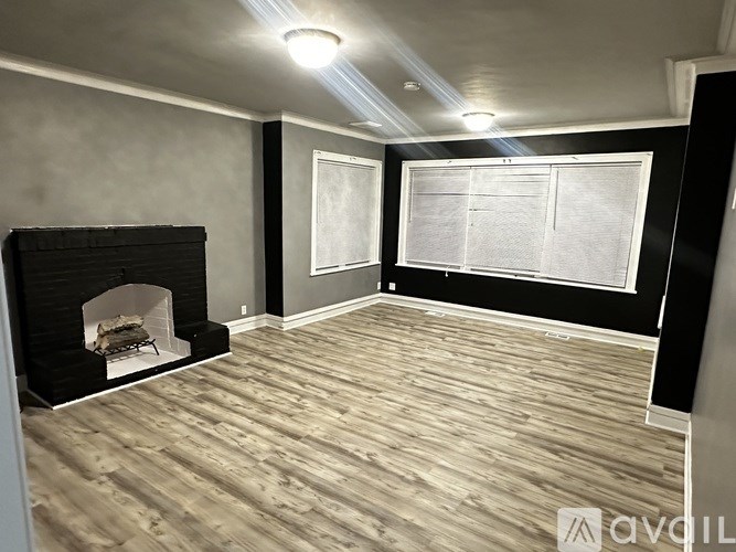 A room with a fireplace and wooden flooring.
