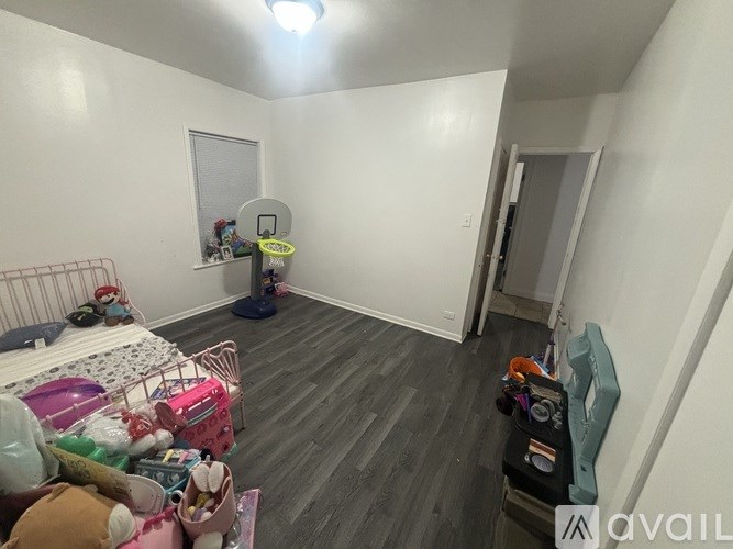 A room with a basketball hoop and a bed with a pink headboard.