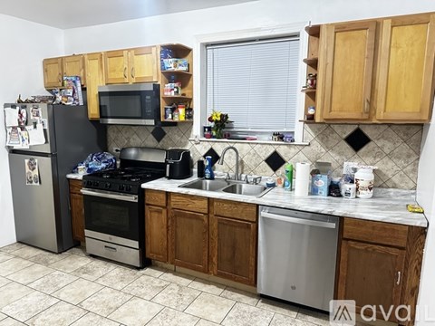 A kitchen with wooden cabinets and a black refrigerator.