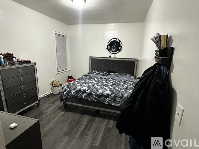 A bedroom with a bed, dresser, and mirror.
