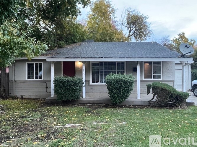 A small house with a red door and a satellite dish on the roof.
