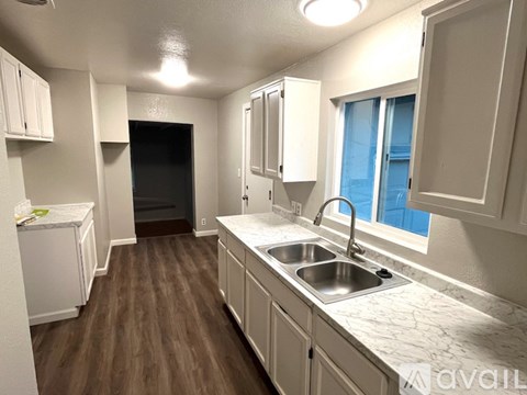 A kitchen with white cabinets and a sink.
