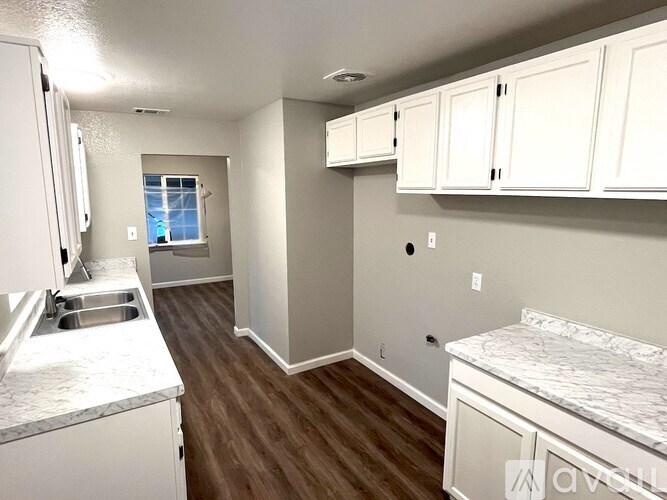 A kitchen with white cabinets and a marble countertop.