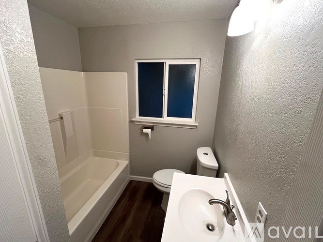 A small bathroom with a toilet, sink, and bathtub.