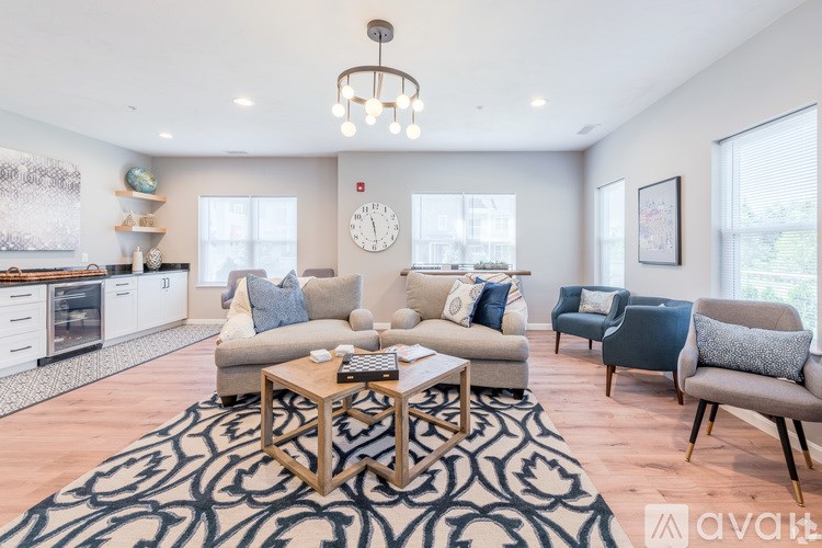 A living room with a patterned rug and a coffee table in the center.