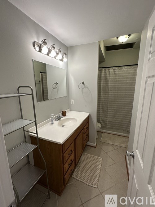 A bathroom with a sink, mirror, and light fixture.