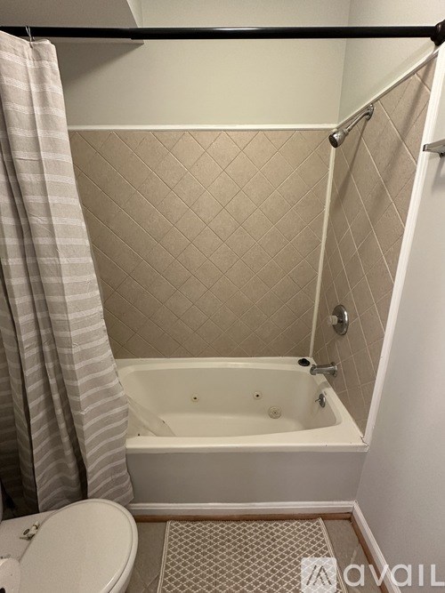 A bathroom with a white tub and a shower curtain.