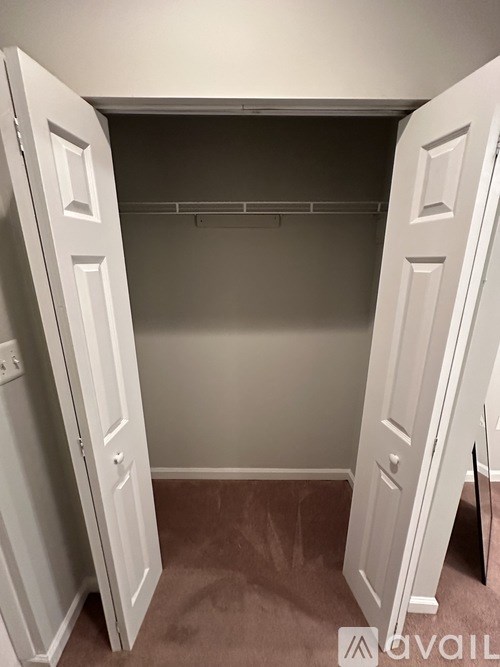 A white closet with two doors open.