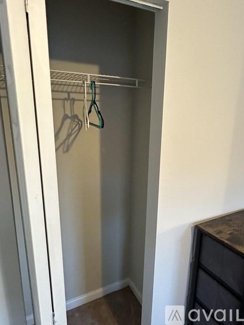A white closet with a hanger on the rod.