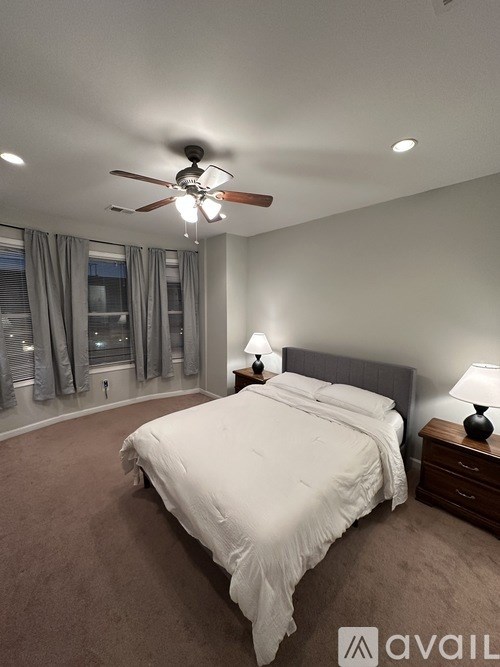 A bedroom with a large bed and a ceiling fan.
