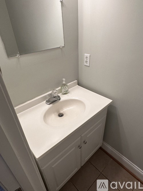 A white sink in a bathroom with a mirror above it.