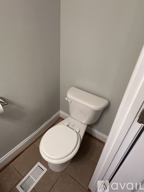 A white toilet in a small bathroom.