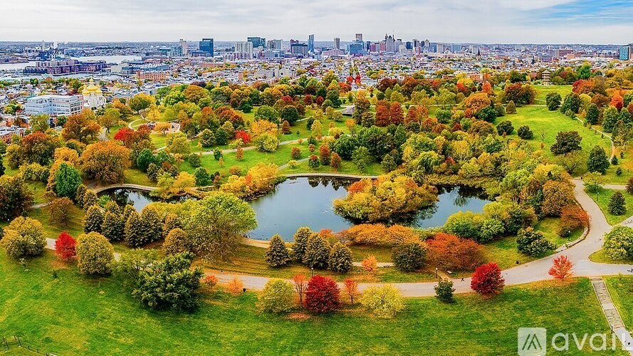 A park with a lake and trees in autumn colours.