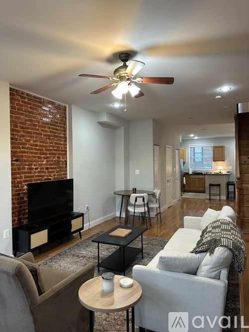 A living room with a brick wall and a fireplace.