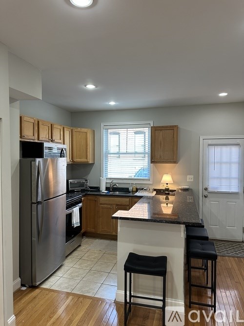 A kitchen with wooden cabinets and a black countertop.